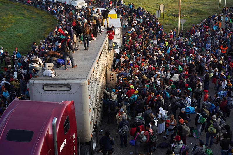 Migrantes tratan de subir a un camión en México. © Reuters