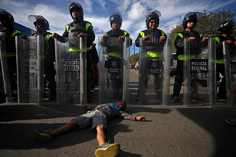 Un niño hondureño de seis años frente a la policía mexicana, en la entrada del puerto El Chaparral. © Reuters